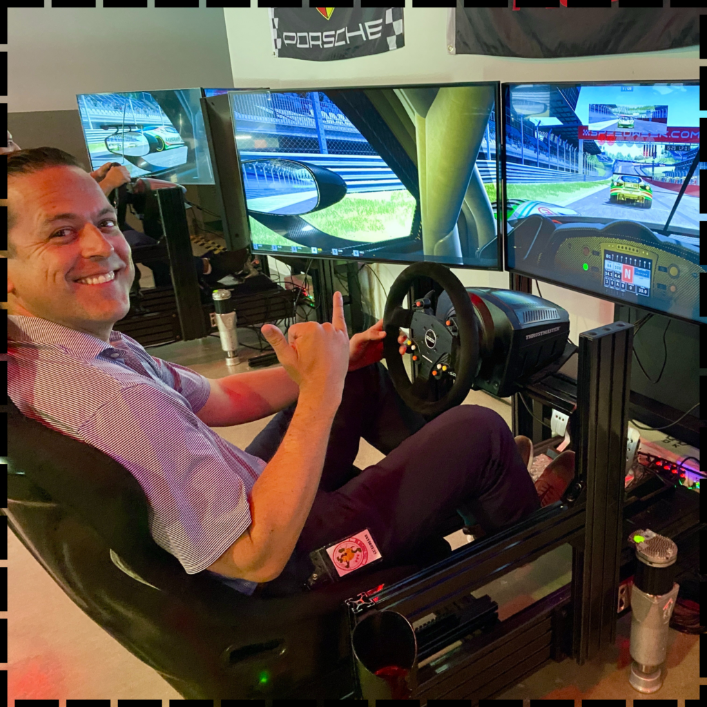 Man gripping race car steering wheel inside simulator