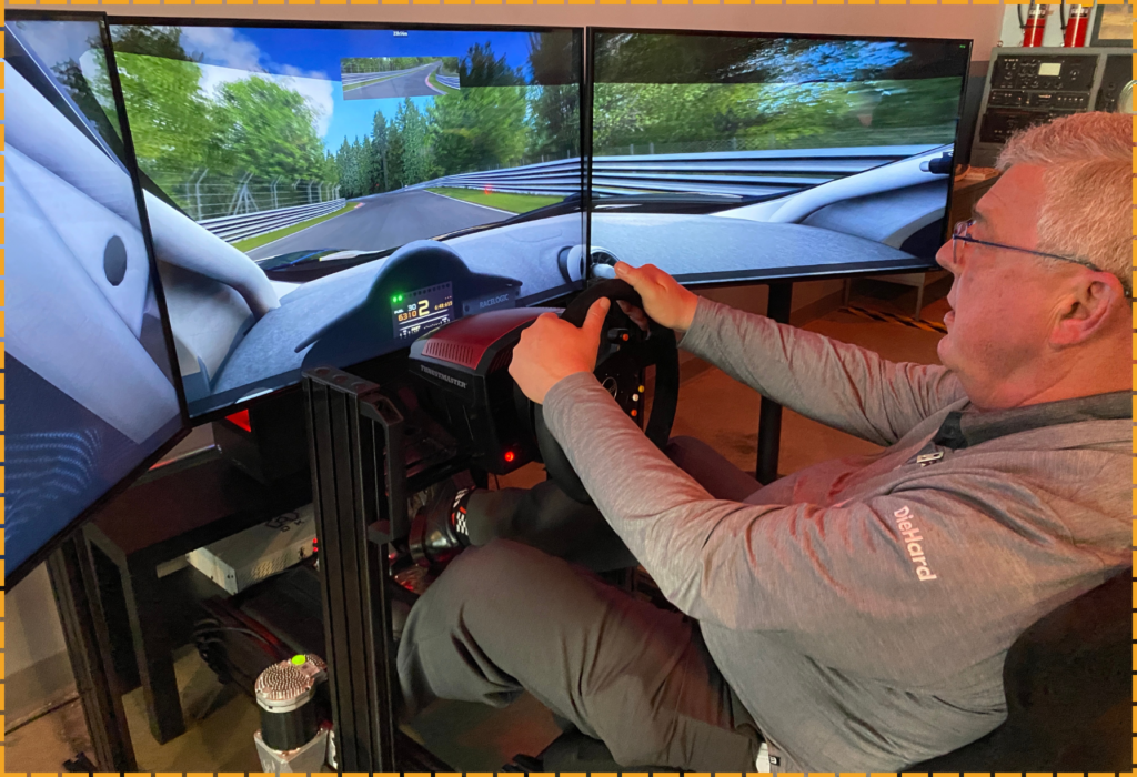 Man gripping race car steering wheel inside simulator