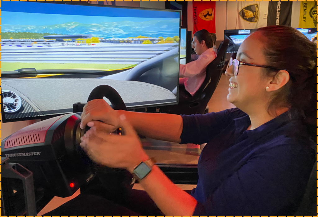 Adult gripping race car steering wheel inside simulator